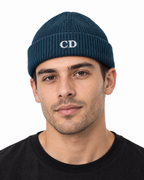 CD Fisherman Beanie — Deep Teal, worn front view on a white background with white CD embroidery.