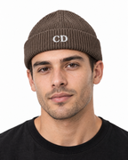CD Fisherman Beanie — Mocha, worn front portrait on a white background with white CD embroidery.