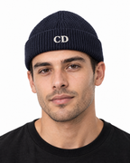CD Fisherman Beanie — Navy, worn front portrait on a white background with white CD embroidery.