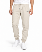 Joggers CD Mover — Natural Raw, vista frontale del capo indossato su sfondo bianco con ricamo CD nero