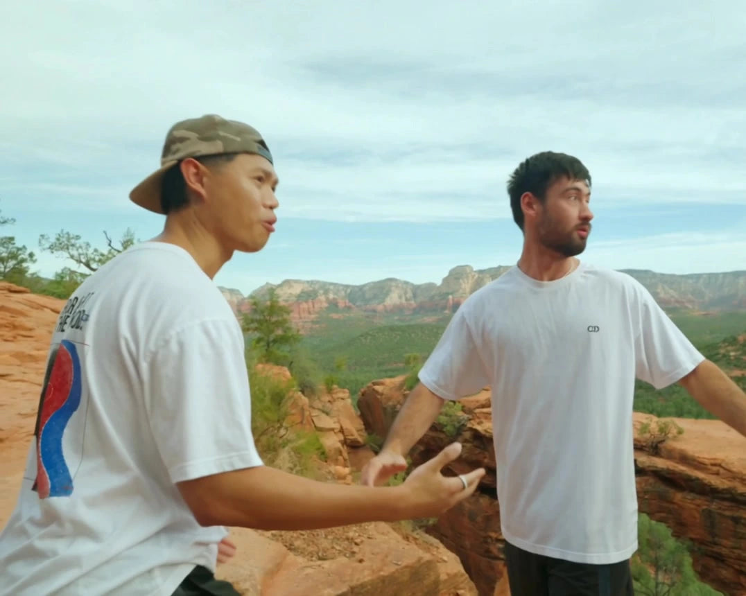 White Augusta Human Error T-shirts viewed from front and back in a rocky landscape