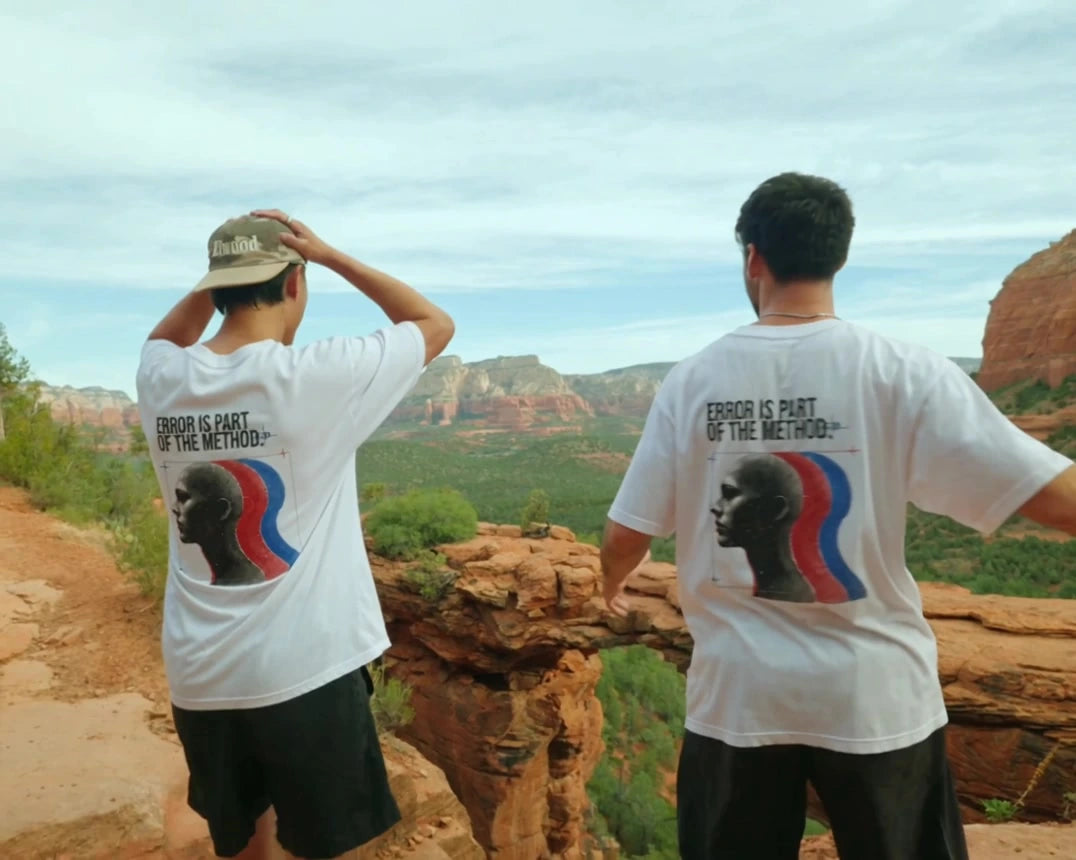 Two people showing the back graphics of white Augusta Human Error T-shirts