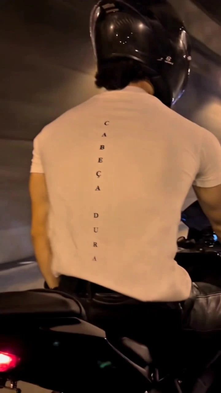 Back of an Augusta cream T-shirt with vertical Cabeça Dura lettering on a motorcycle