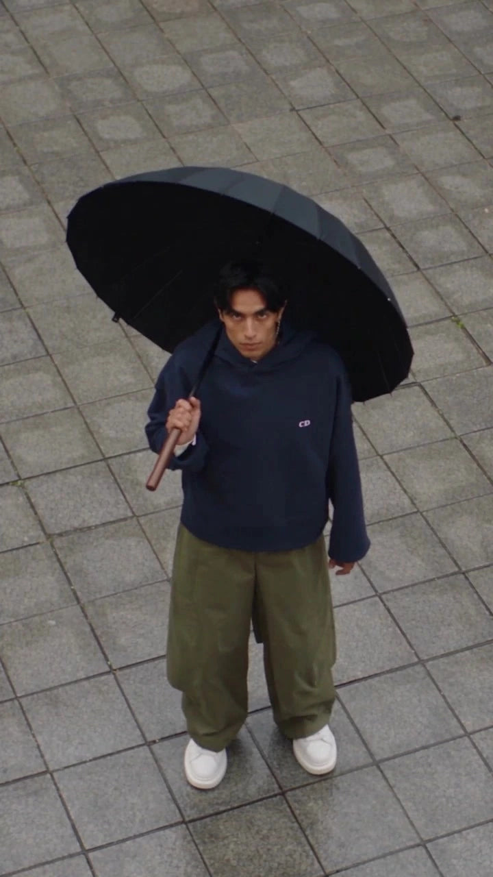 Front of the navy Augusta Rare Form hoodie under an umbrella