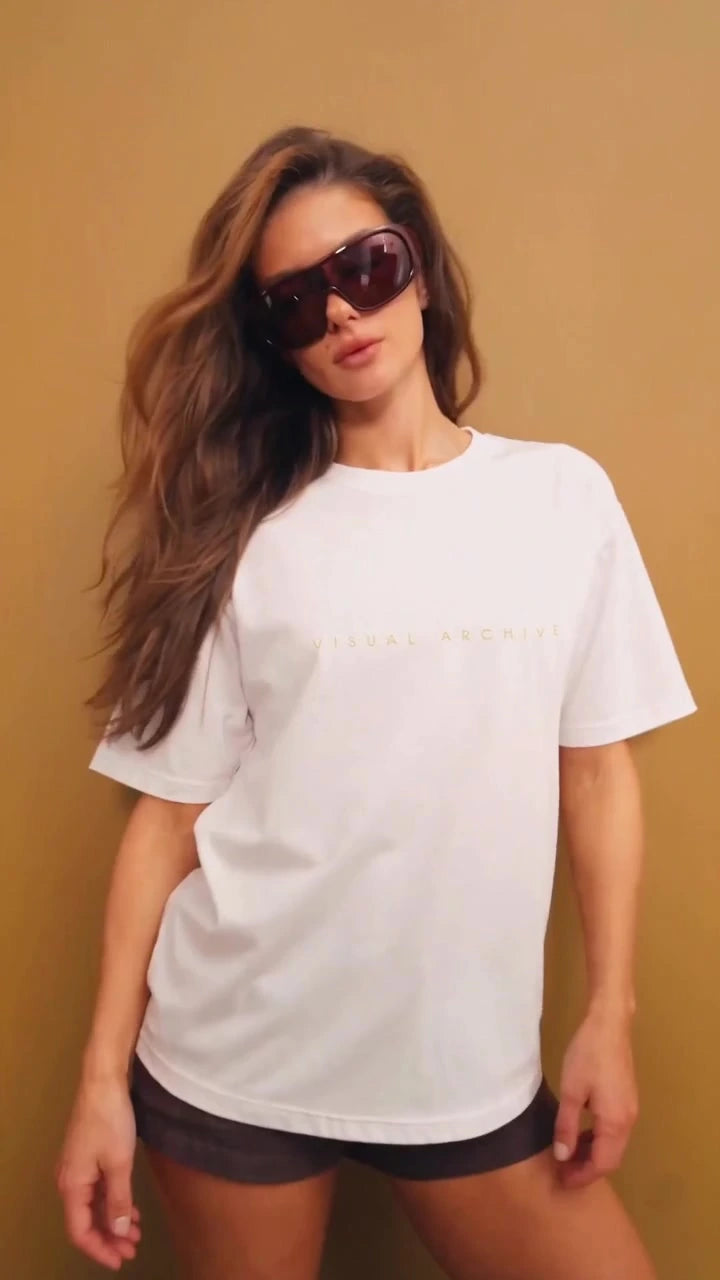 White Augusta Visual Archive T-shirt worn against a warm ochre wall